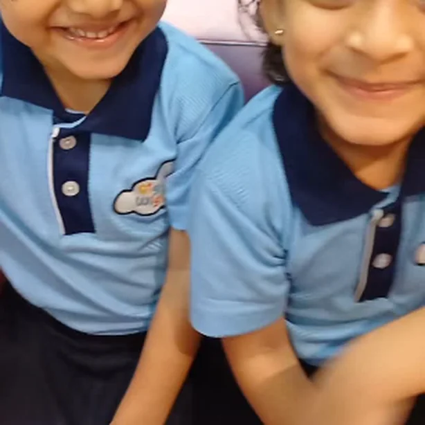 Two friends in school uniform smiling for the camera